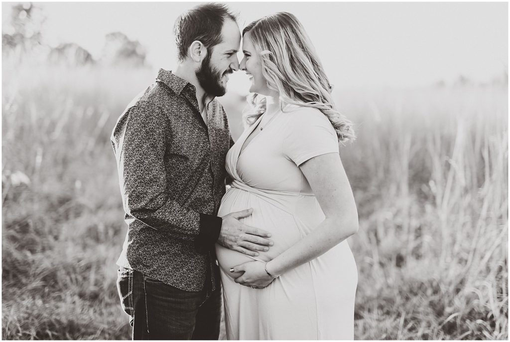 black and white married pregnant couple holding belly smiling