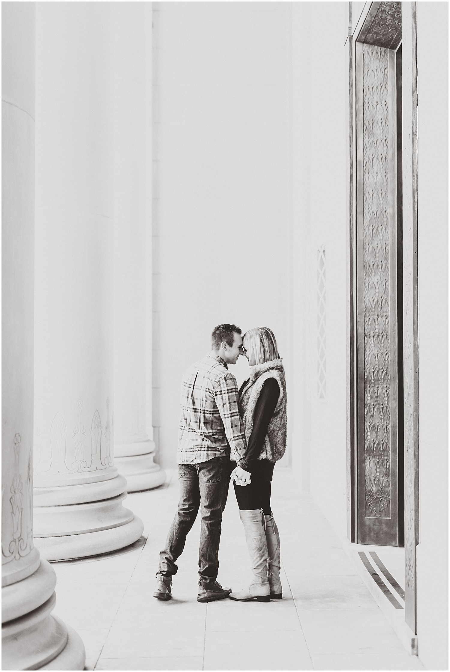 couple touching foreheads outside nelson atkins art museum winter engagement session