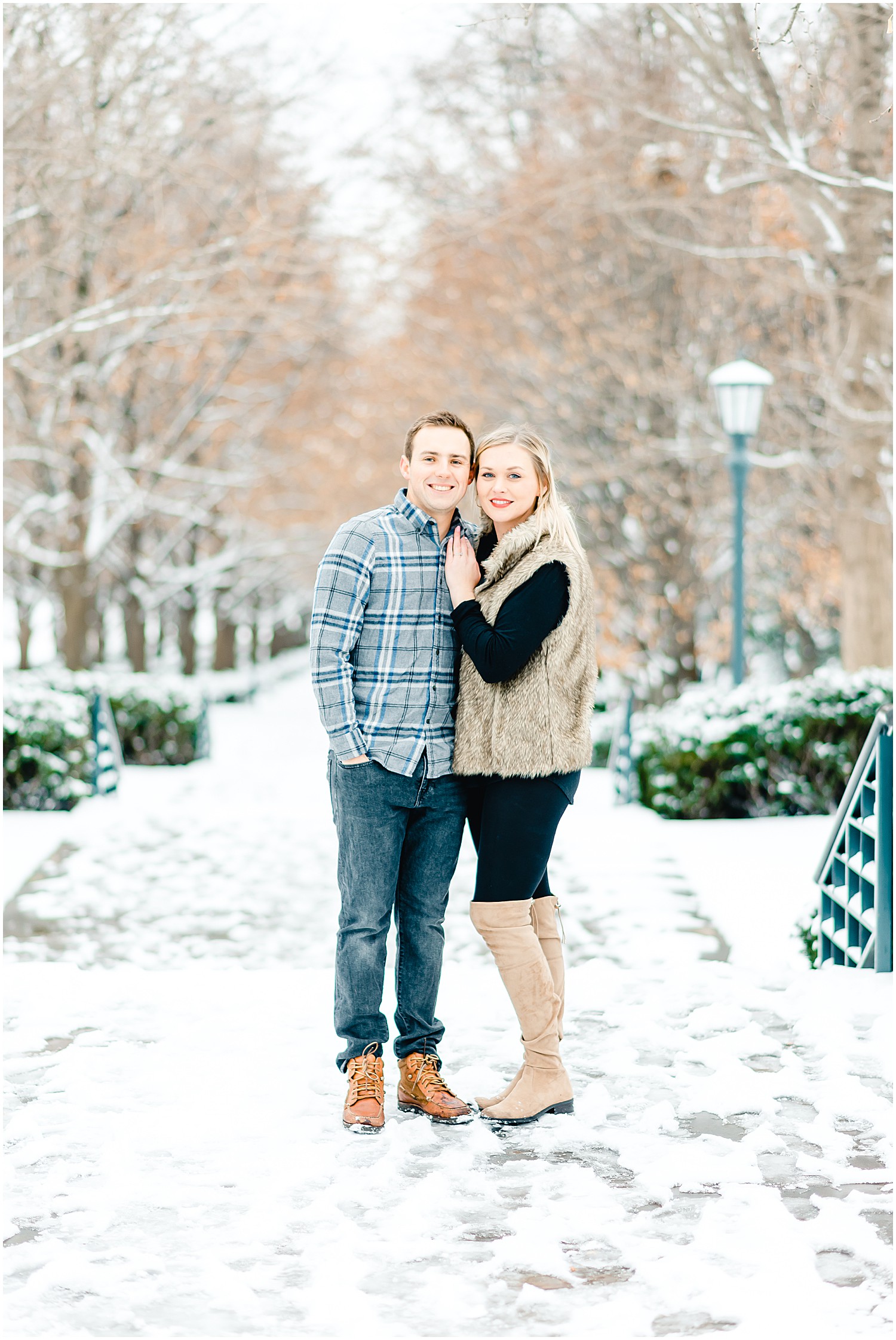 couple standing on snowy sidewalk winter engagement session