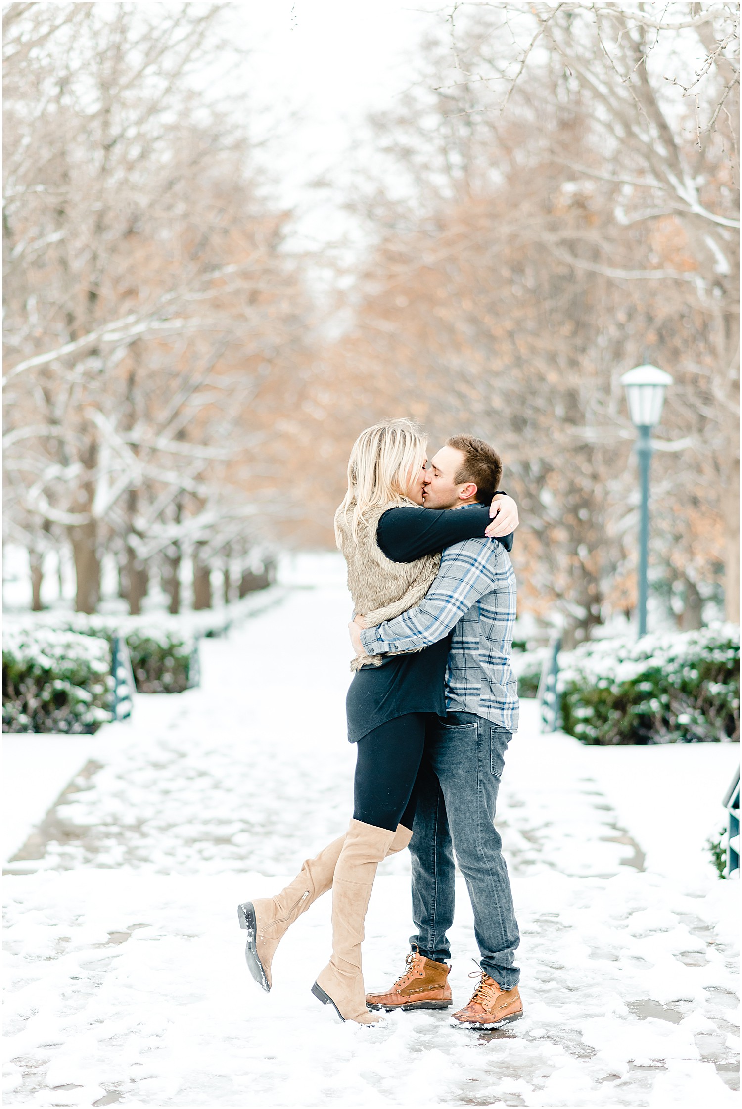 couple kissing on sidewalk winter engagement session