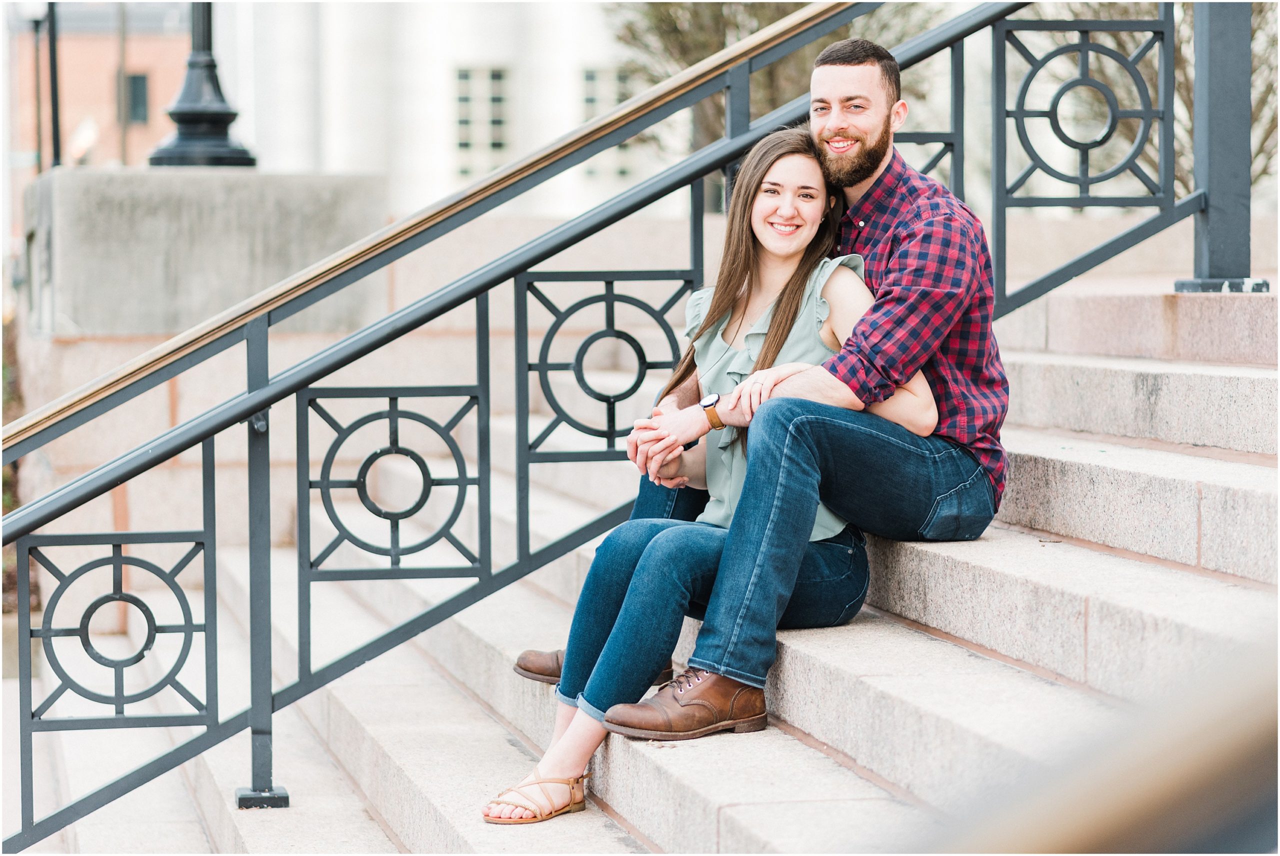 engaged couple sits on concrete stairs in downtown jefferson city mo for engegement session