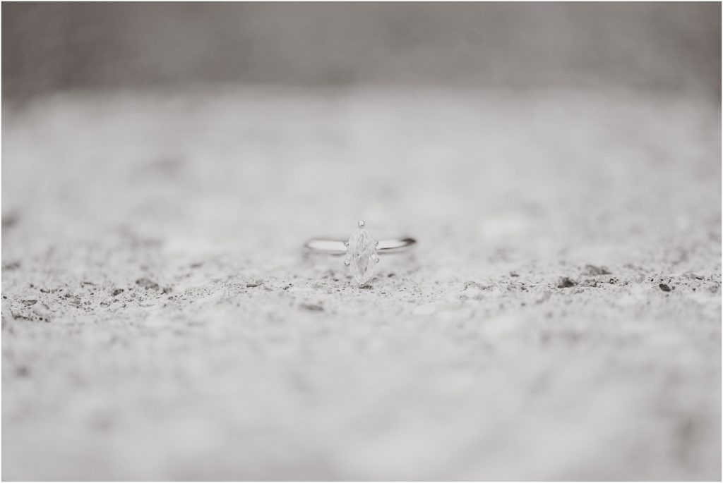 diamond engagement ring on concrete in black and white