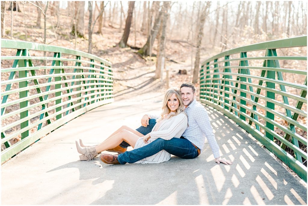 couple sitting on green bridge st. louis engagement session