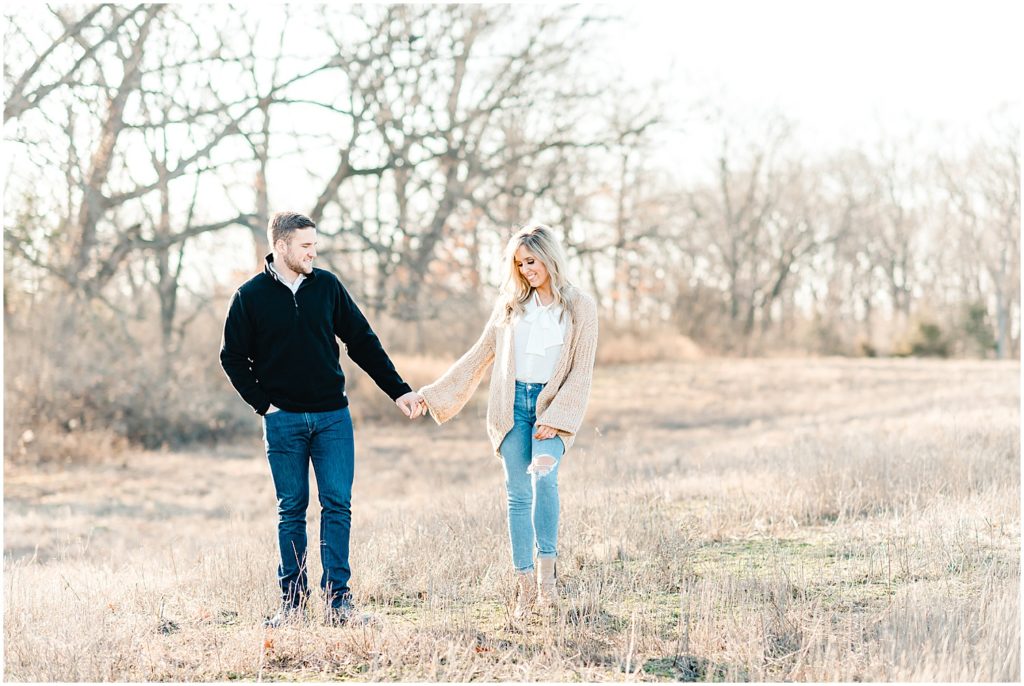 couple walking in grasses st louis engagement session