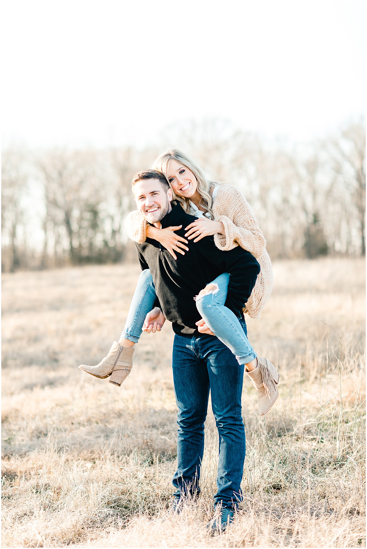 engaged couple piggy back ride in field