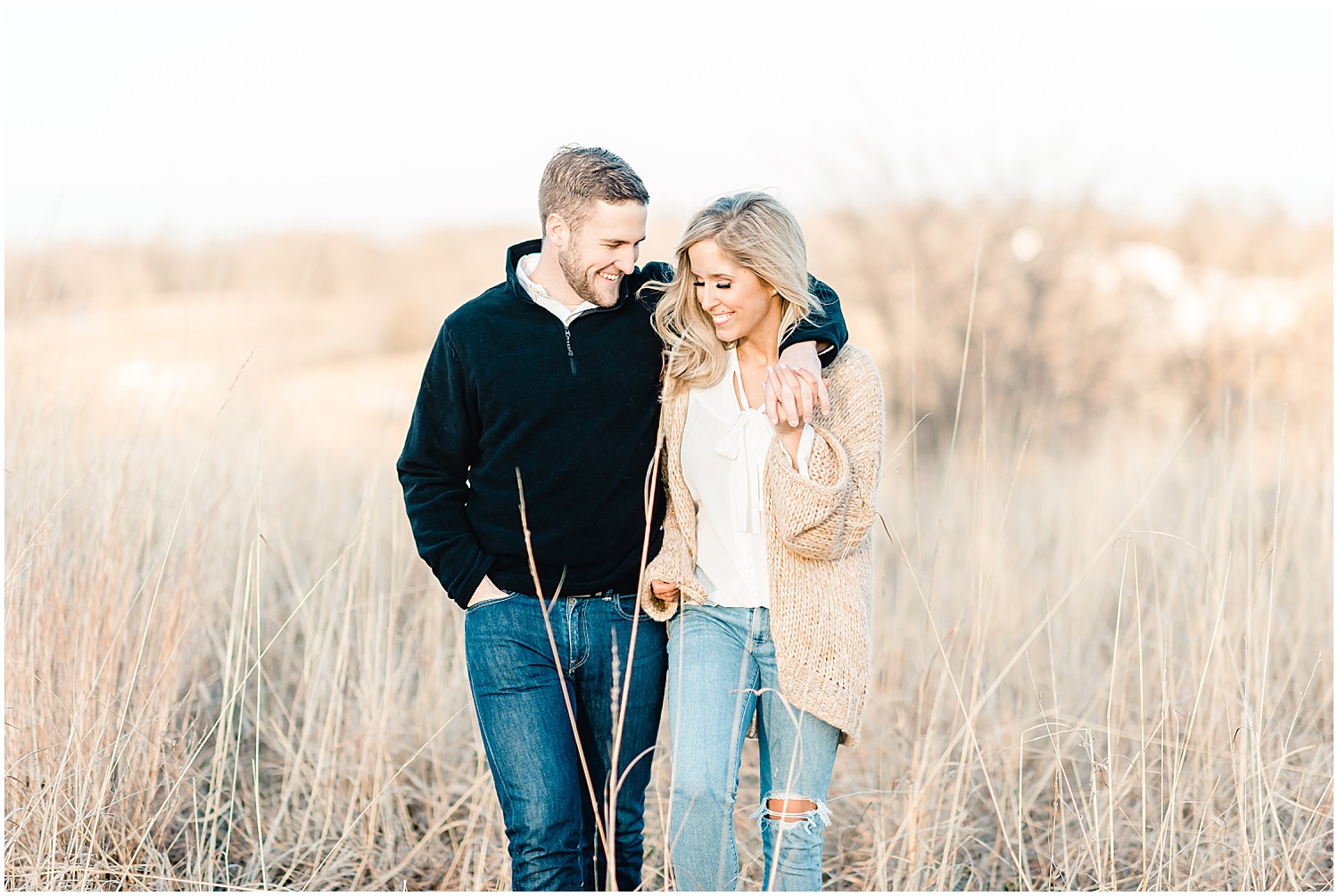 couple walking in sunset in tall grasses
