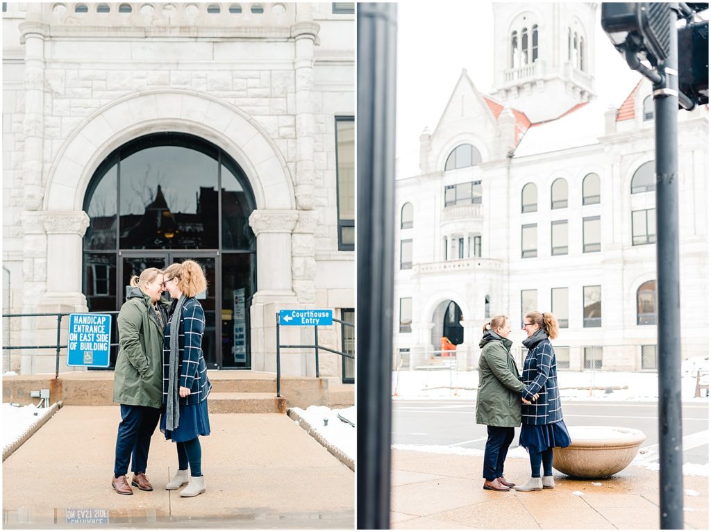 female couple standing outside snowy courthouse wedding