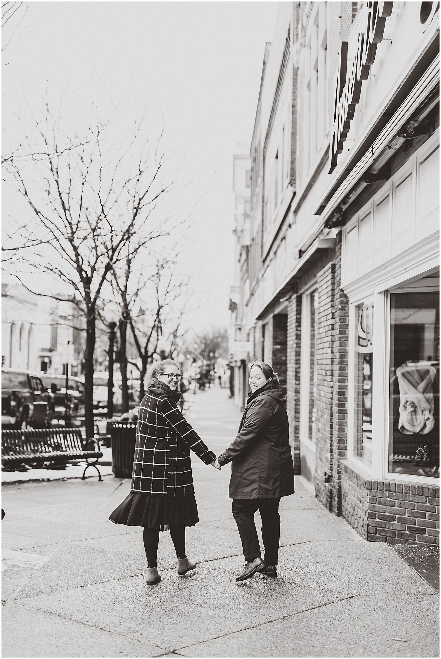 female couple holding hands walking down sidewalk jefferson city