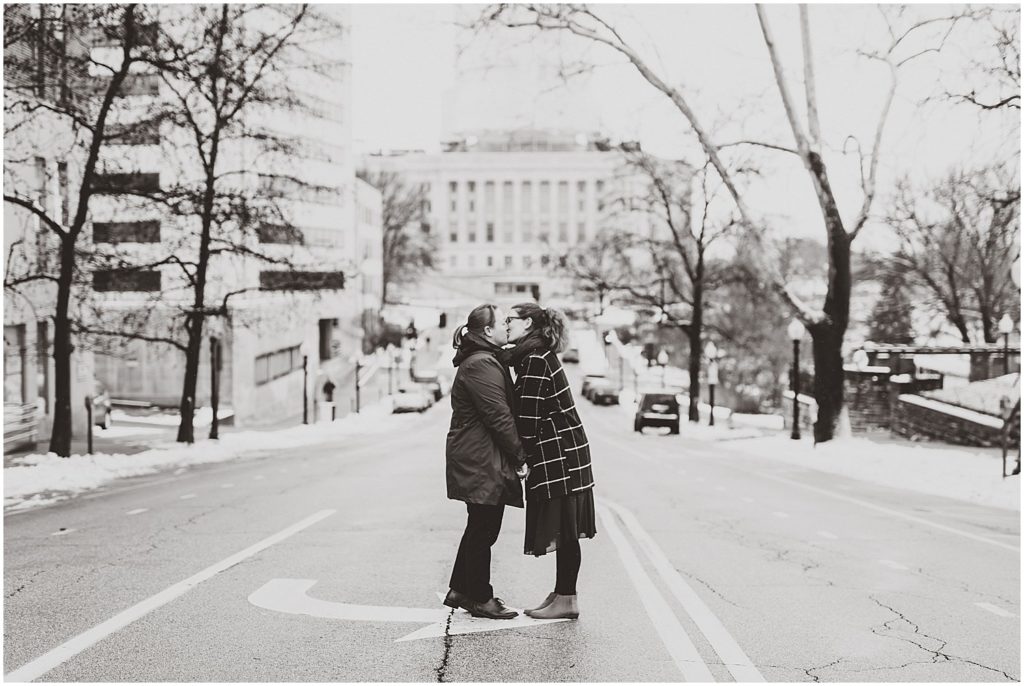 female couple kissing in street black and white