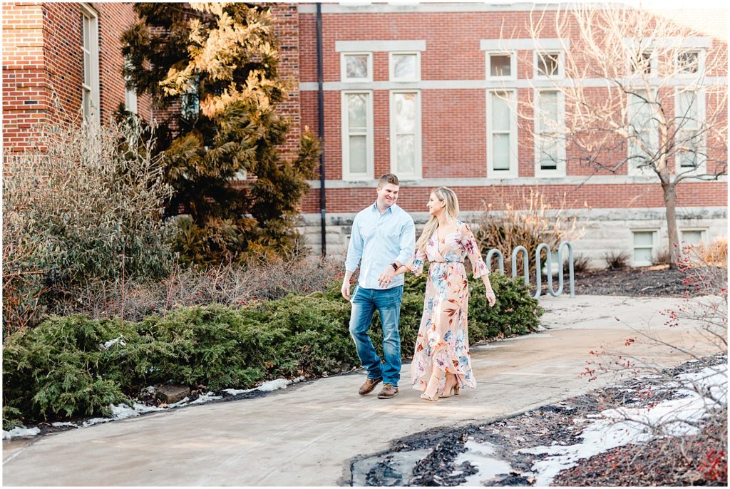 Engaged couple posing on Mizzou Campus for Columbia, MO engagement session couple walking on sidewalk