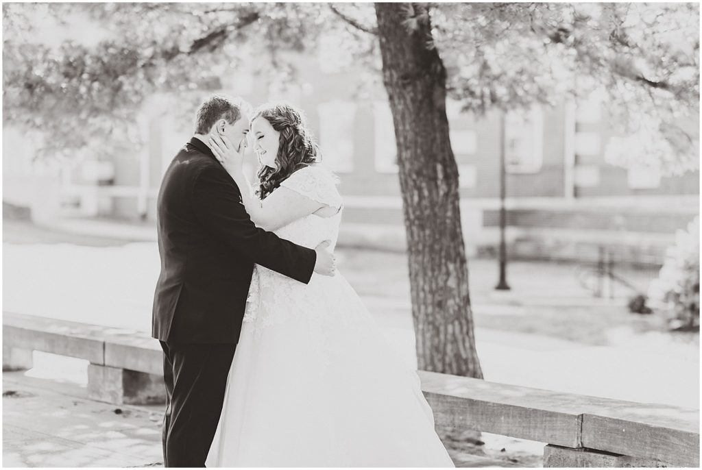 bride and groom hugging under tree in black and white