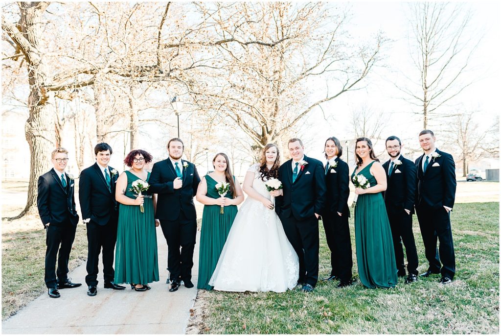 wedding party posing on stephen's college campus emerald green dresses and ties