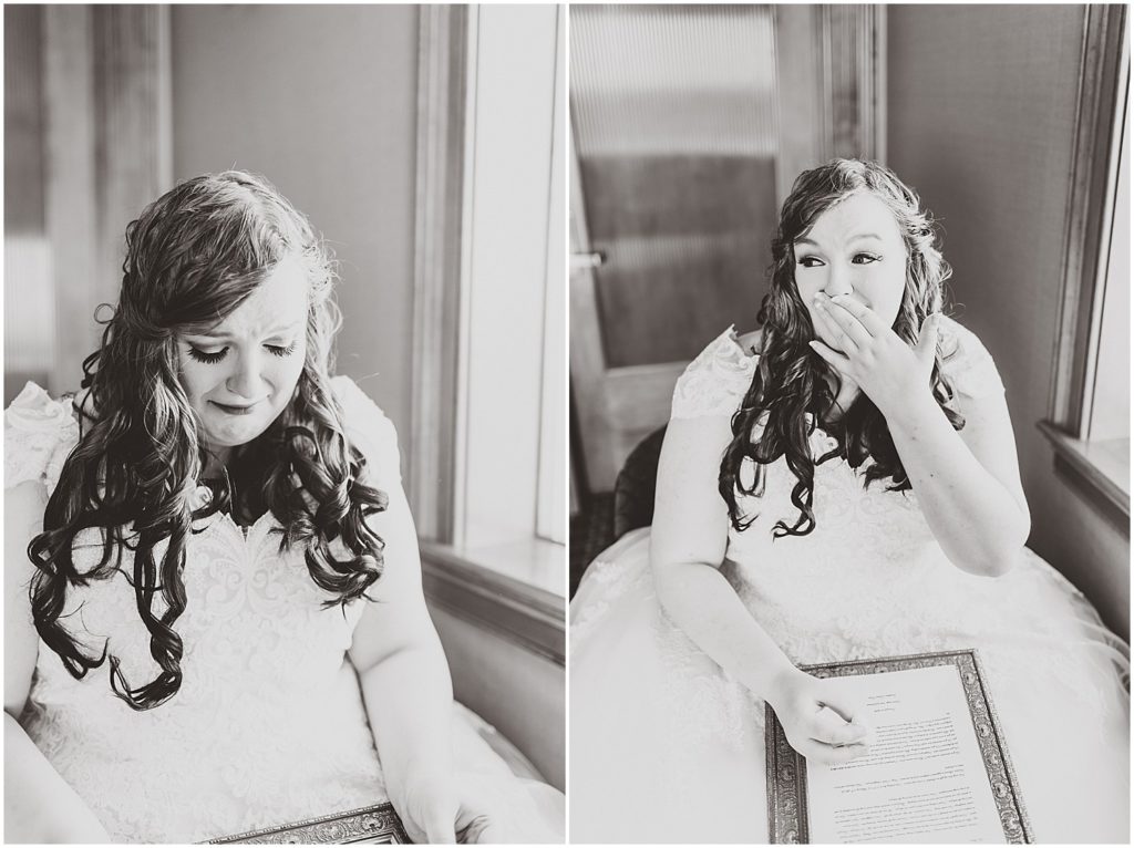 bride crying opening gift from fiancé in black and white