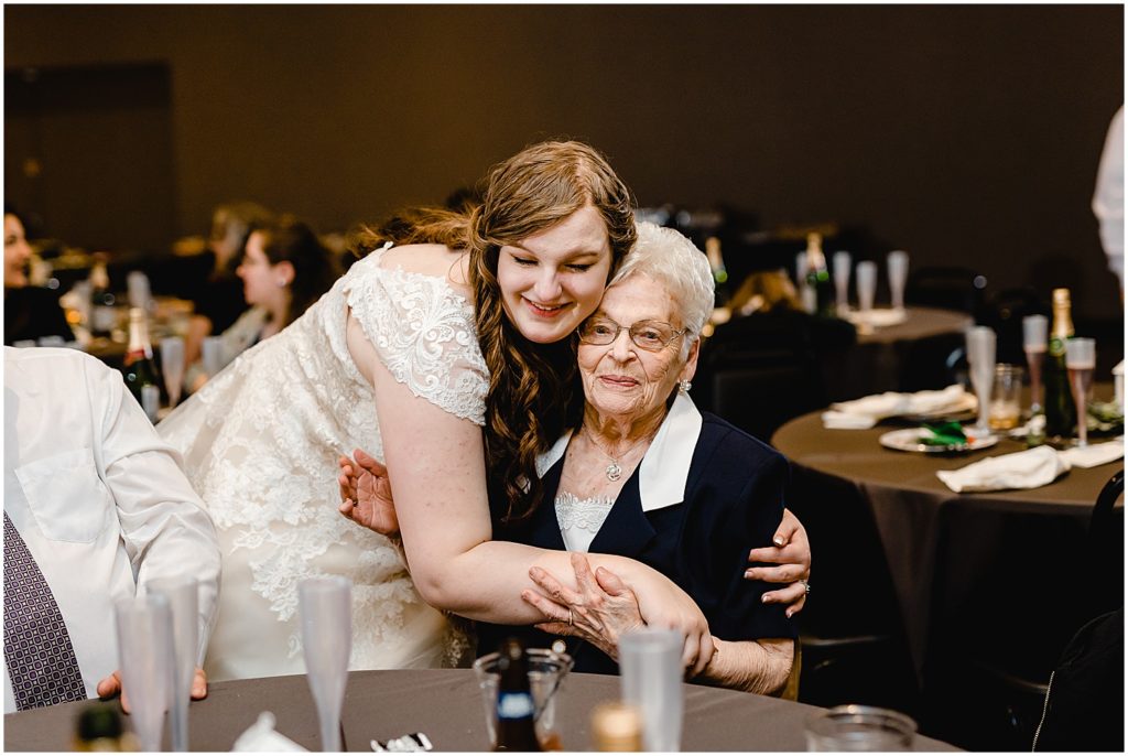 bride hugging her grandma during wedding reception