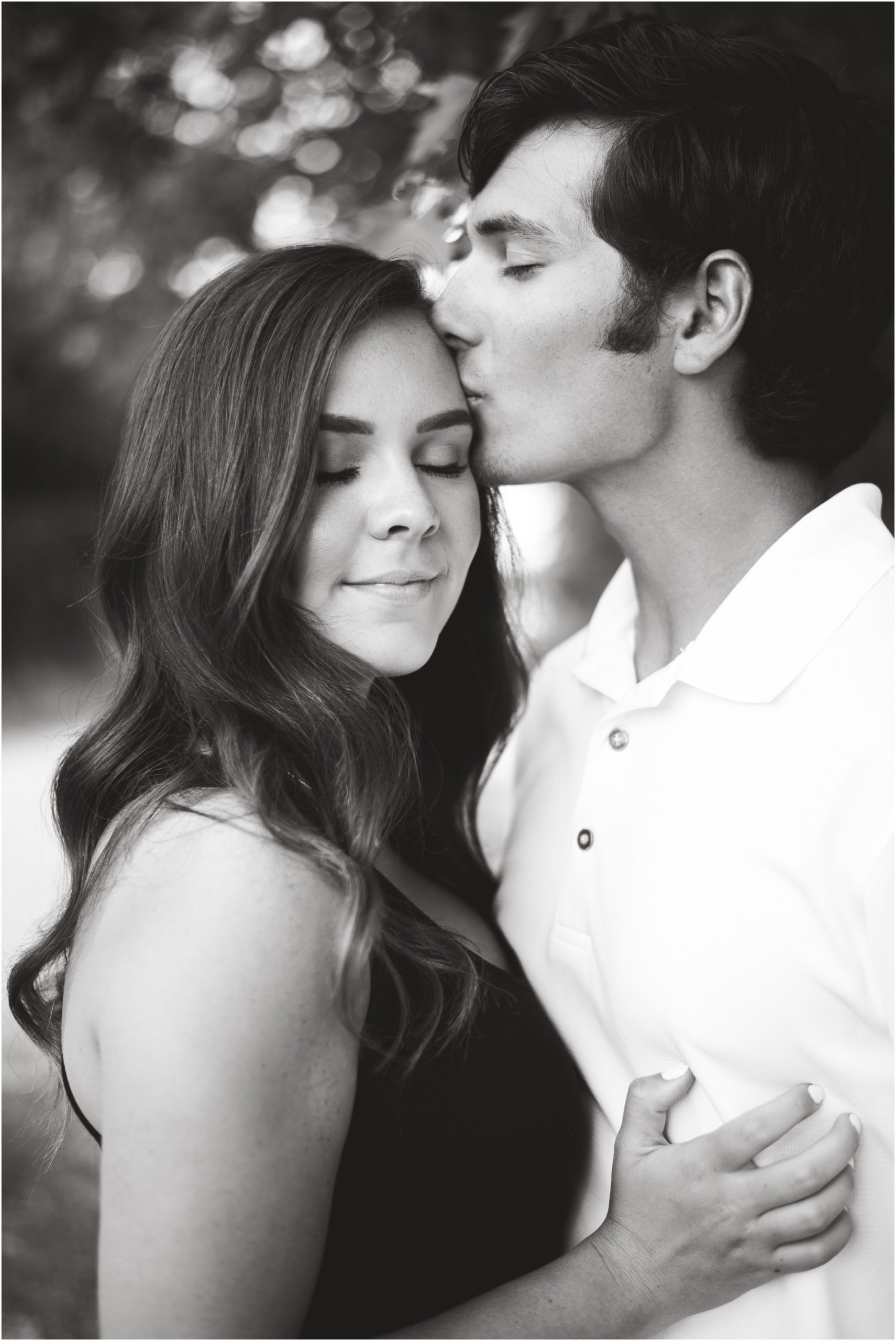black and white image of boy kissing girl for engagement photos