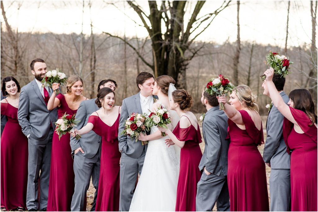 wedding party photo of bride and groom kissing and wedding party cheering