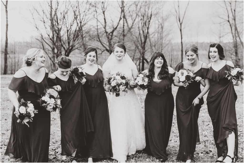 black and white photo of bride walking with her bridesmaids 