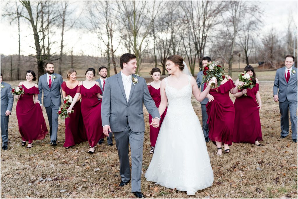wedding party photo of bride and groom walking and smiling