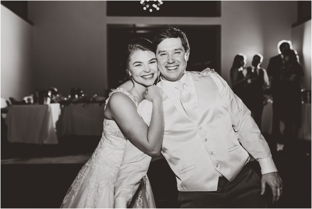 black and white photo of bride and groom smiling at the end of their wedding reception