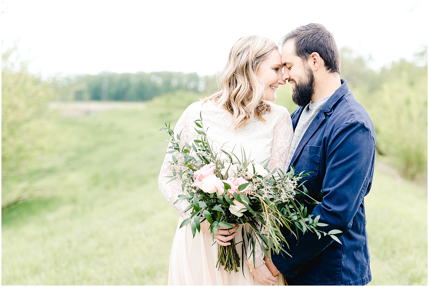 married couple with bouquet head to head nuzzling