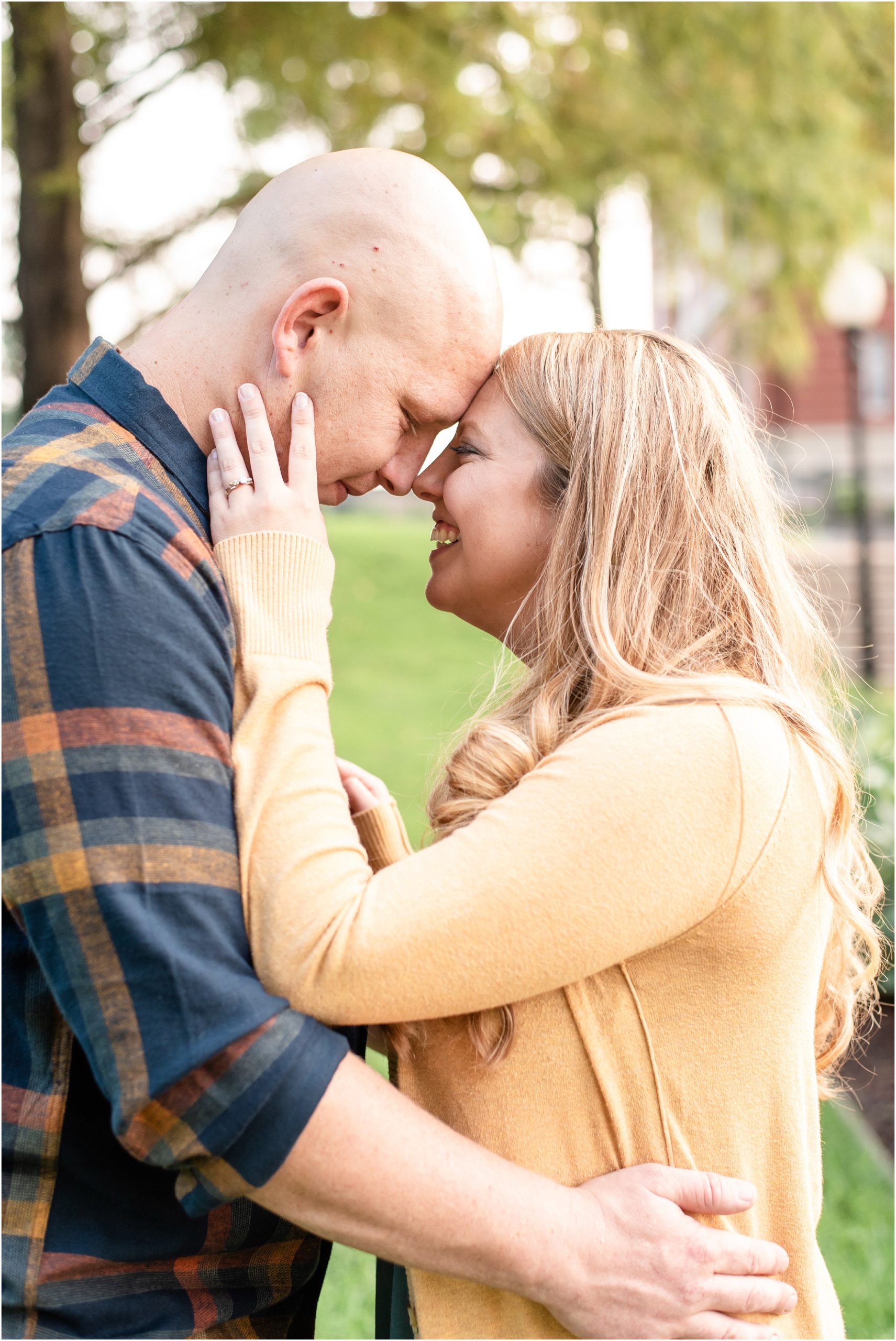 engaged couple wearing navy and mustard colors touching foreheads for Jefferson City engagement photos