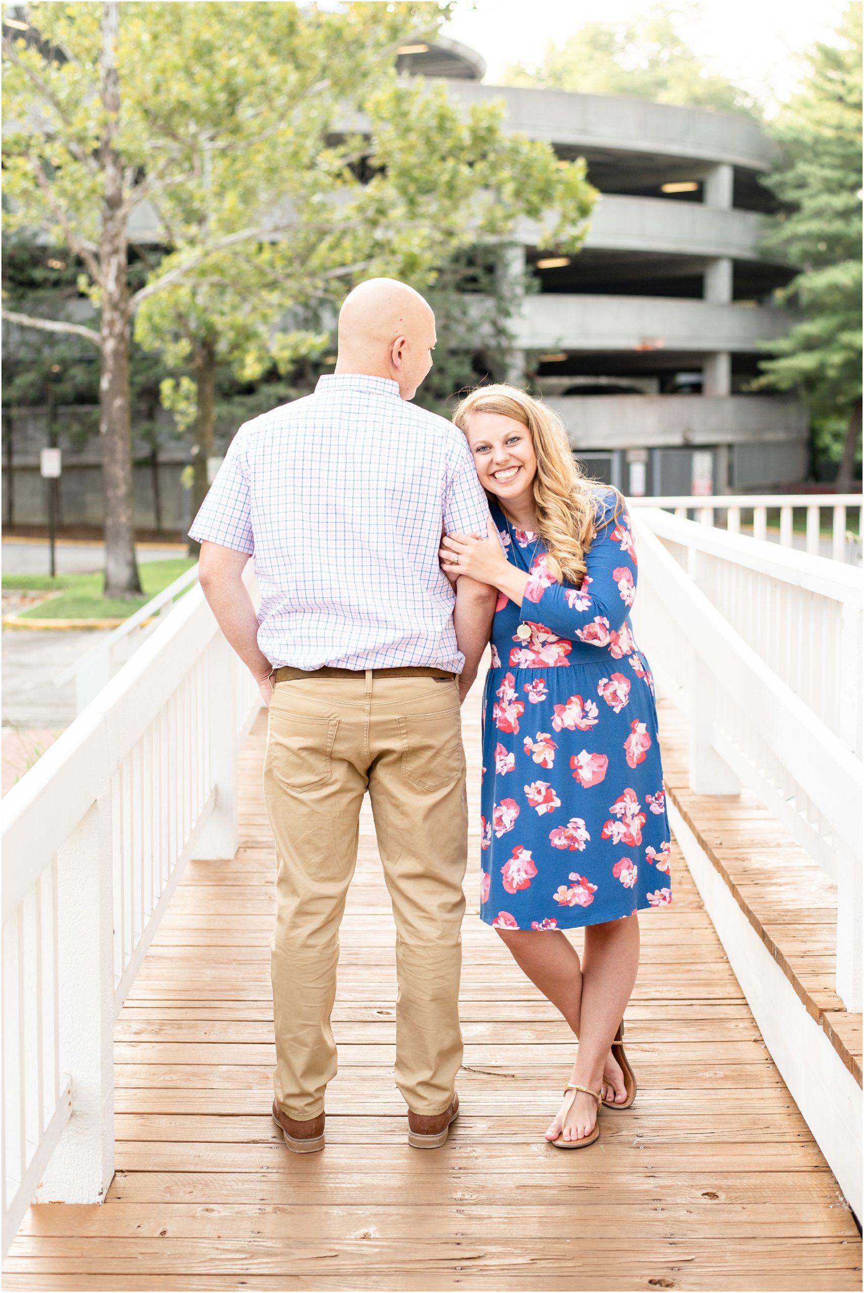 couple standing on walkway with white railings for downtown Jefferson City, mo engagement photos