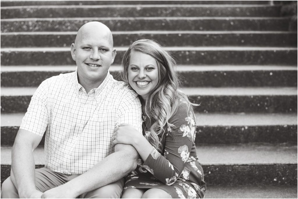 black and white image of couple sitting on steps of governor's mansion for engagement photos