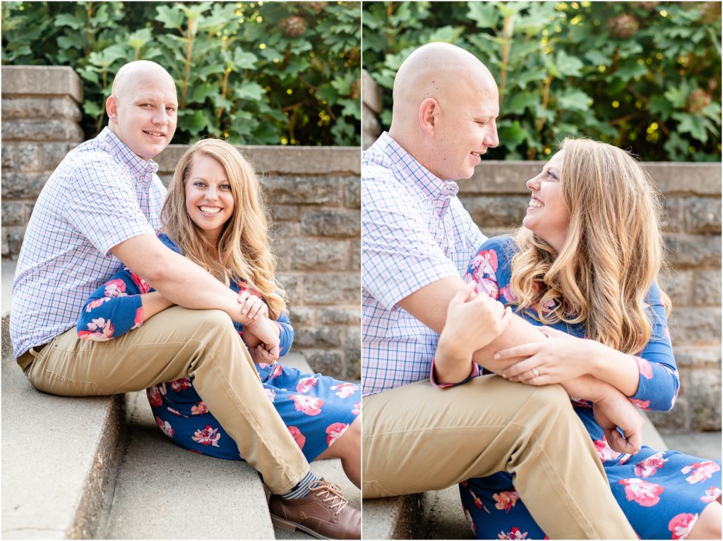 engaged couple sitting on stairs with greenery in the background for engagement pictures
