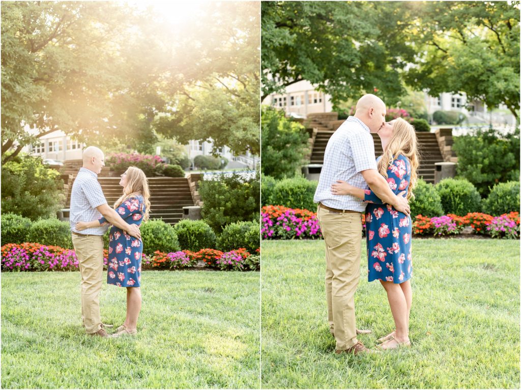 couple standing in sunlight and grass with flowers in the background at the missouri governor's garden for Jefferson City engagement photos