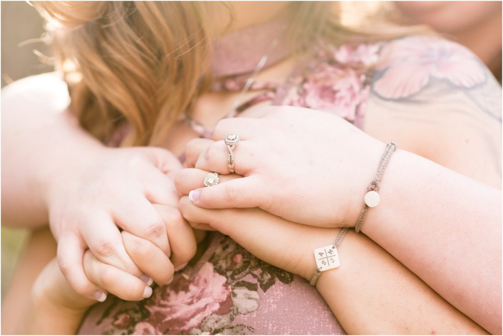 detail photos of two females holding hands and diamond engagement rings and personalized bracelets for engagement photos