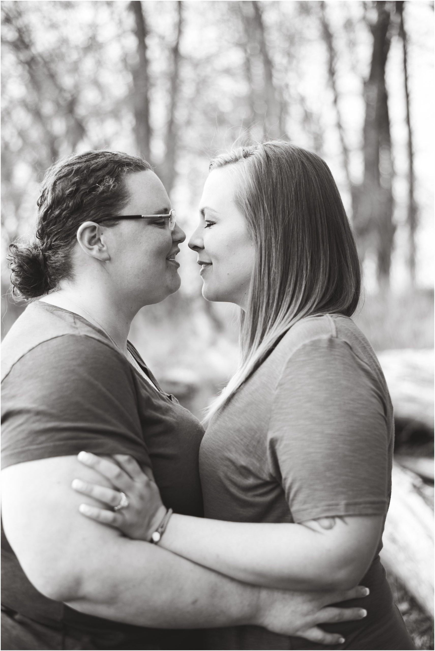 black and white photo of lesbian couple smiling and kissing each other during noren river access engagement photos