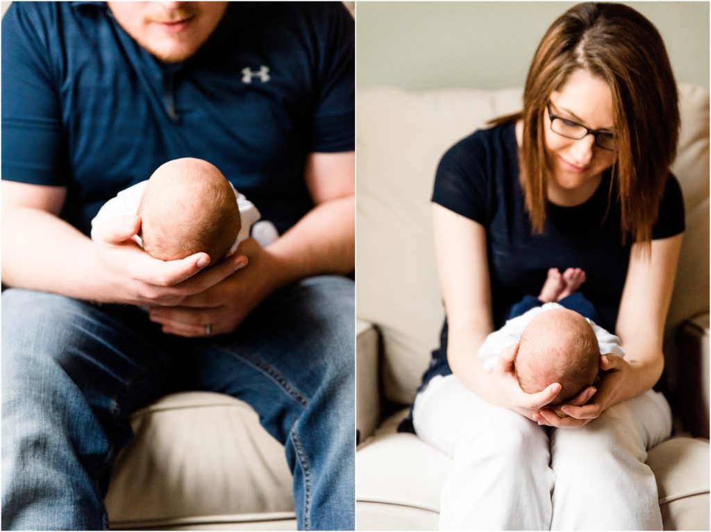 mom and dad sitting and holding newborn boy on lap with focus on baby's head