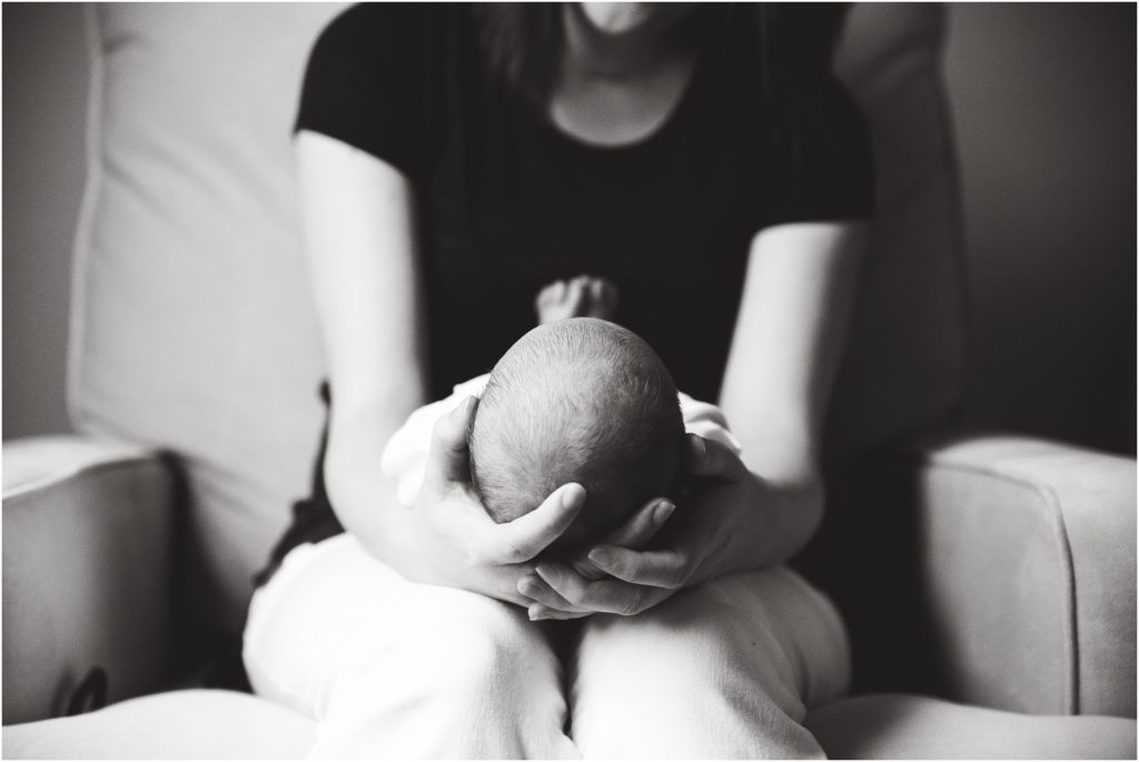 black and white image of mom holding baby boy on lap