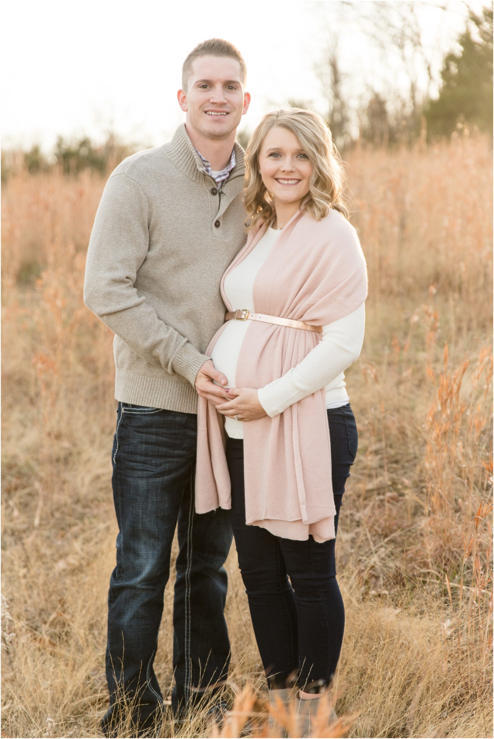 couple wearing fall clothing standing in field at binder park maternity session