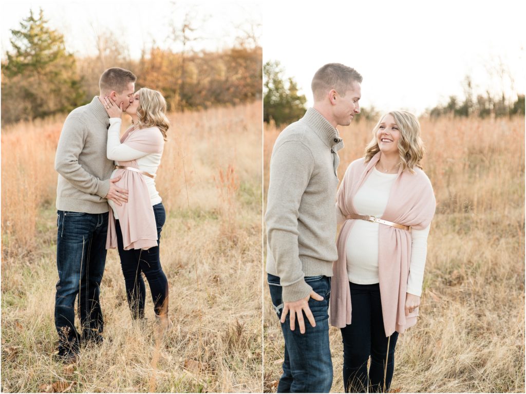 couple kissing and smiling at each other in field for maternity session at binder park