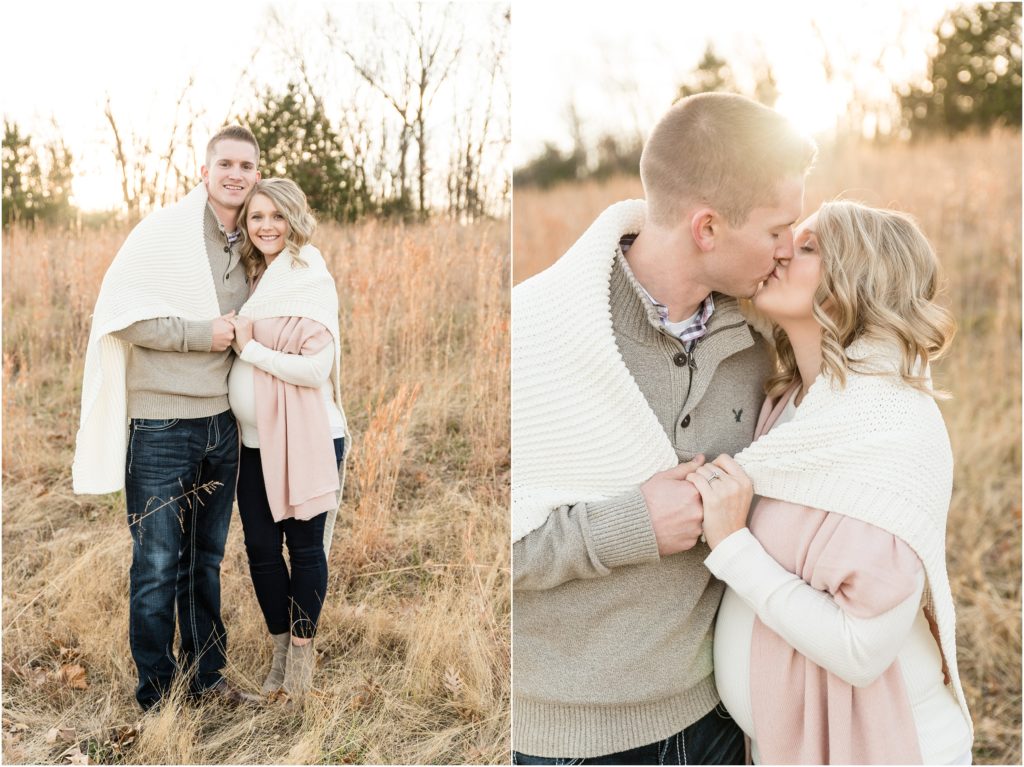 couple kissing with sun flare in grass field for binder park maternity session
