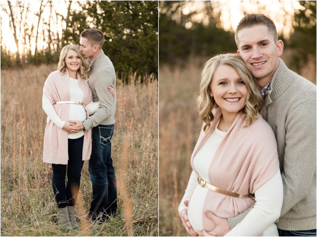 couple smiling at camera holding baby belly for winter maternity session 