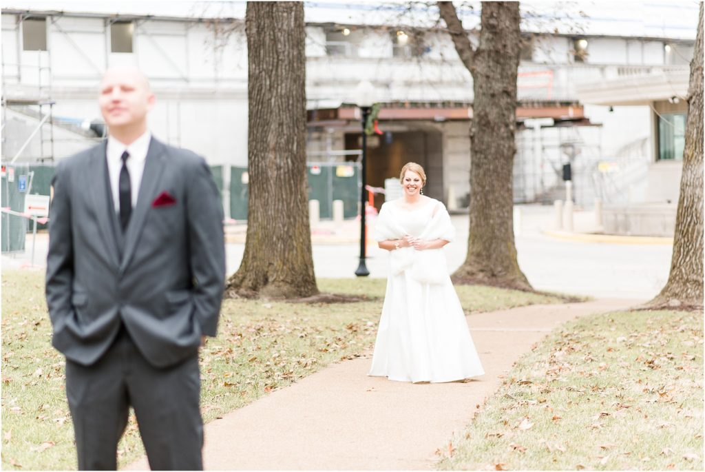 bride walking up to groom during first look outside of missouri state capitol 
