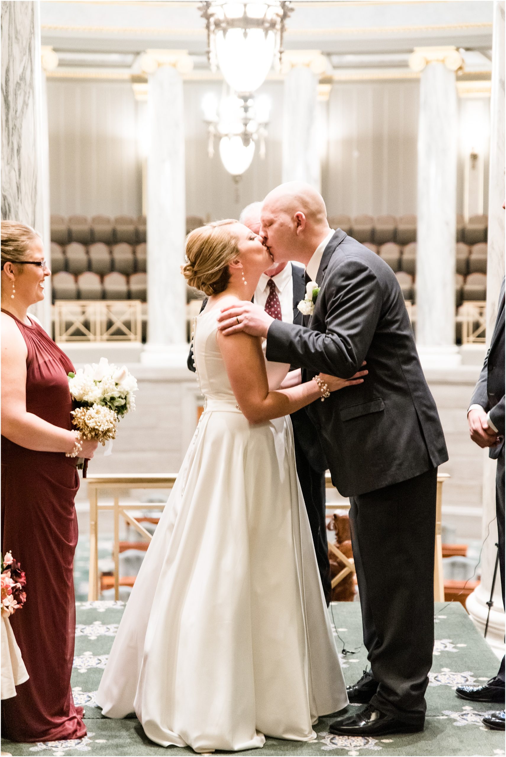 bride and groom first kiss for missouri state capitol wedding in senate chamber mezzanine