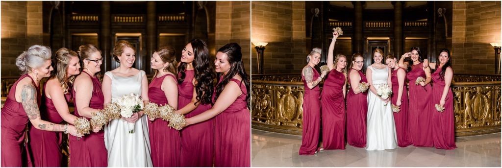 bridal party in maroon dresses with white and gold bouquets posing in missouri state capitol rotunda