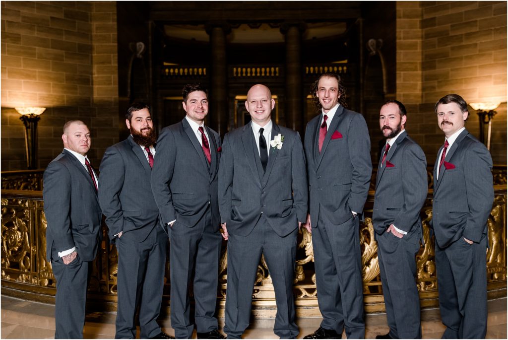 groom and groomsmen with maroon ties posing in capitol rotunda