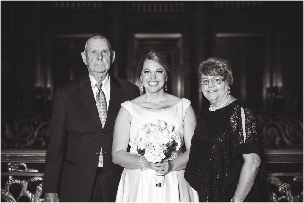 black and white image of bride posing with her grandparents during wedding