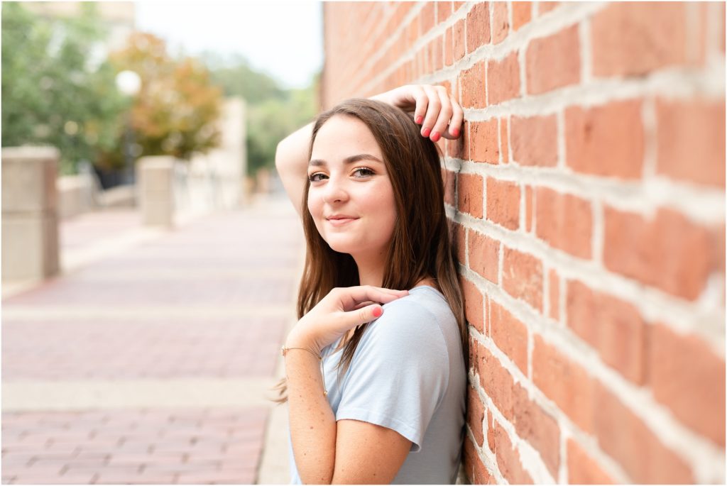 senior girl leaning against brick wall for Jefferson City high school senior portraits