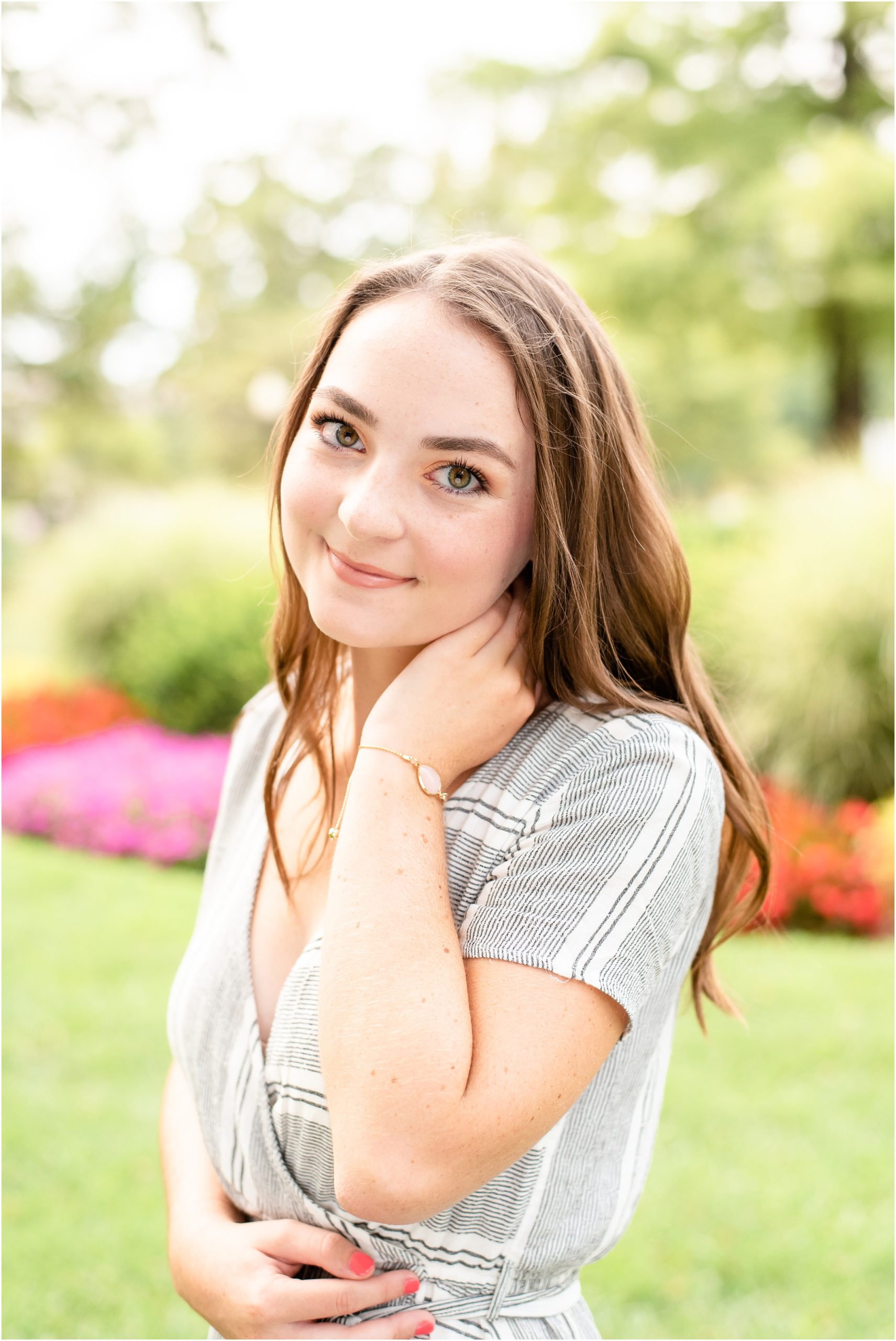 senior girl posing in front of fountain and flowers on the missouri state capitol lawn for jchs senior session
