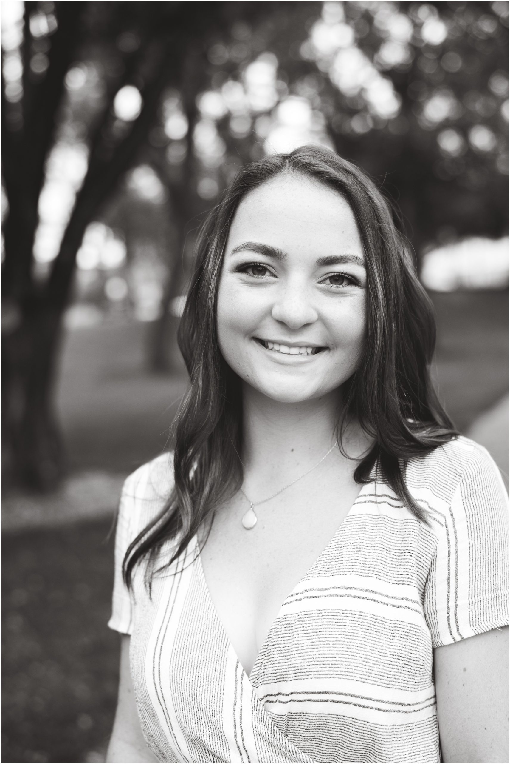 black and white image of senior girl smiling for camera for jchs senior session in downtown Jefferson City, mo