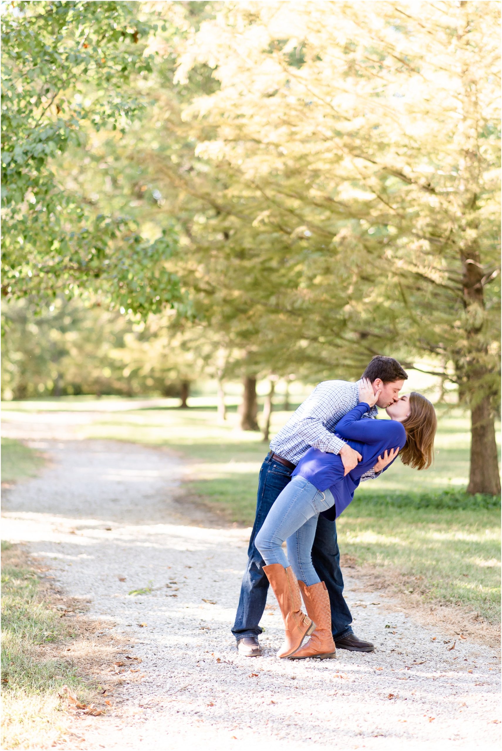 engaged couple doing a dip kiss on gravel path of park for Jefferson City, MO engagement session