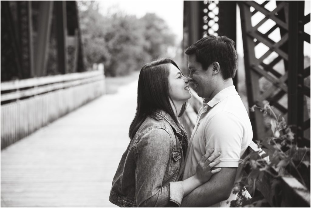 black and white image of couple touching noses on bridge for Jefferson City, mo engagement session