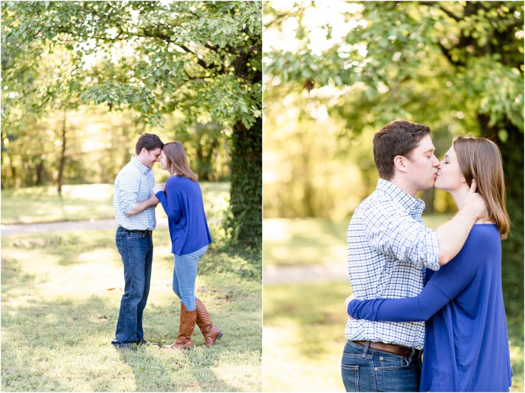 couple touching foreheads and kissing under trees for engagement pictures in a park
