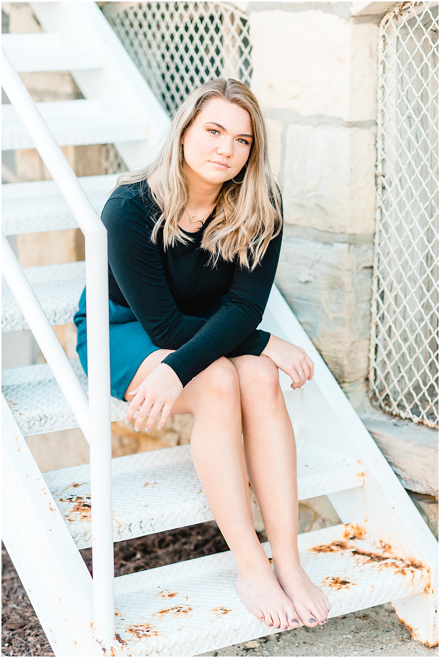 senior girl posing in black shirt for downtown jefferson city high school senior session on white metal staircase