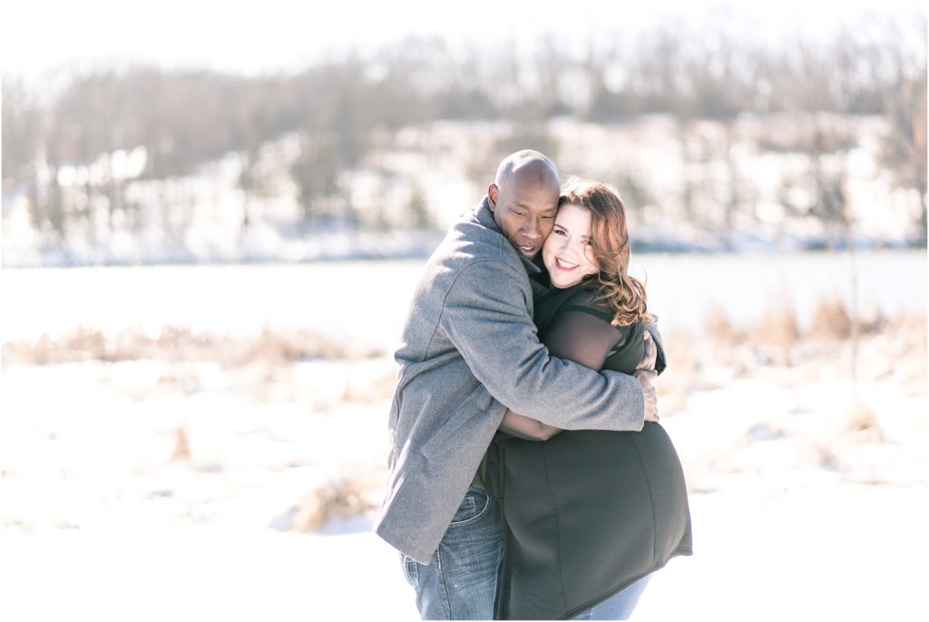 engaged couple hugging in the snow for engagement session